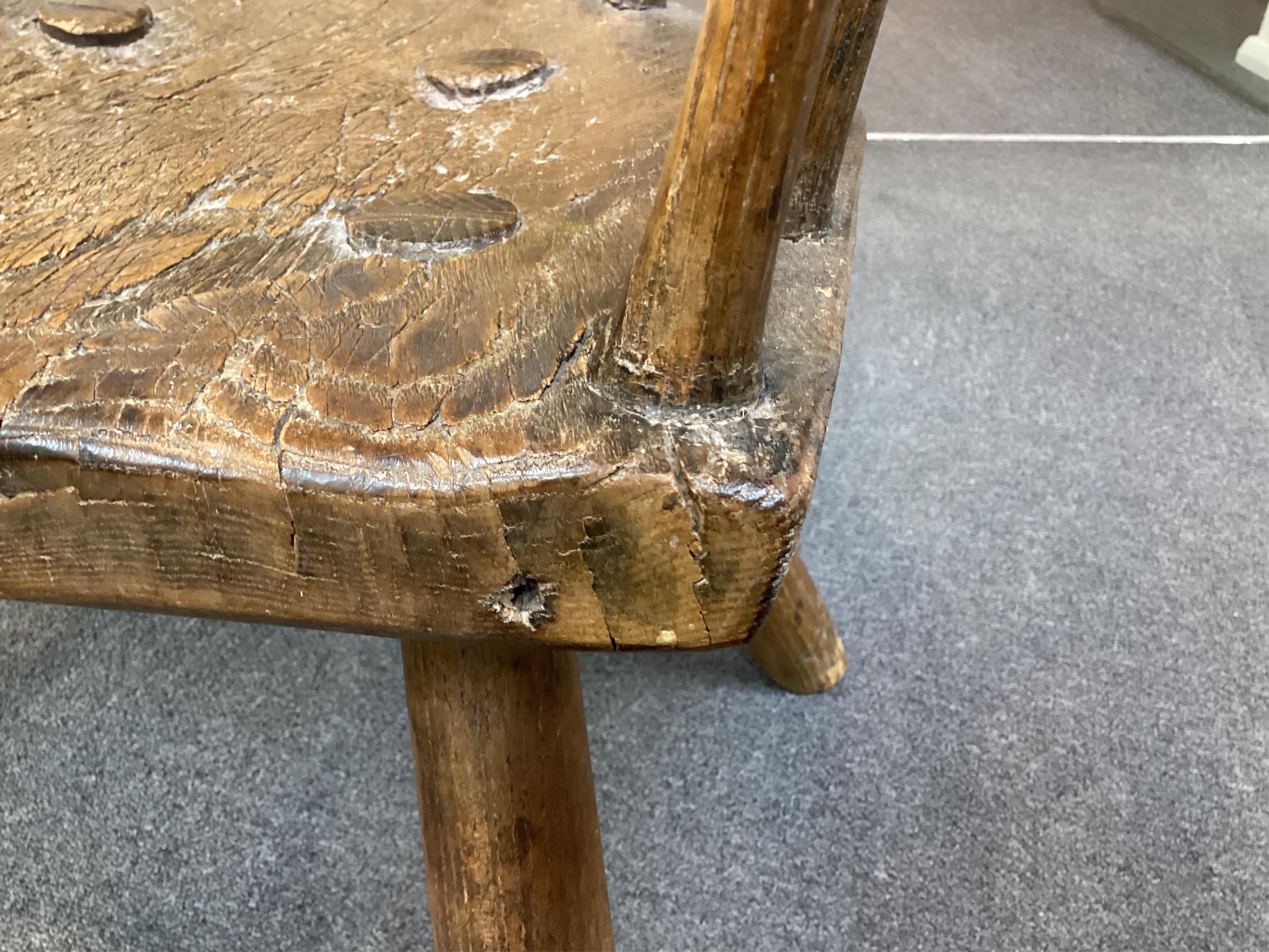 An 18th or 19th century primitive ash and elm Windsor armchair